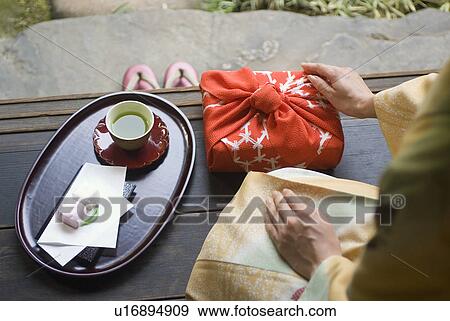 Young woman in kimono touching wrapped gift View Large Photo Image Stock Photo - Young woman in kimono touching wrapped gift. Fotosearch