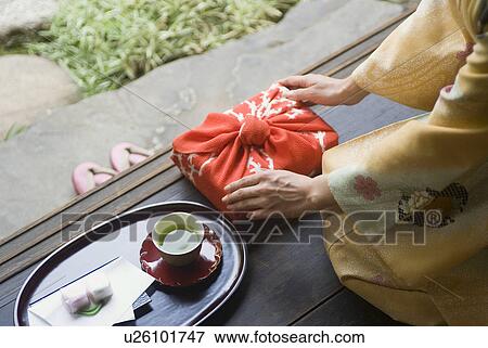 Young woman in kimono touching wrapped gift View Large Photo Image Stock Photo - Young woman in kimono touching wrapped gift. Fotosearch
