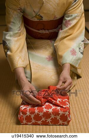 Young woman in kimono wrapping box View Large Photo Image Stock Image - Young woman in kimono wrapping box. Fotosearch