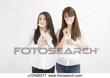 Stock Photo - Two young women holding flowers. Fotosearch