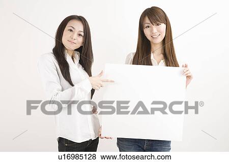 Two young women holding message board View Large Photo Image Stock Photo - Two young women holding message board. Fotosearch
