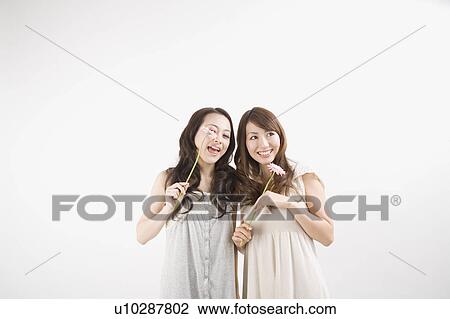 Two young women smiling View Large Photo Image Stock Image - Two young women smiling. Fotosearch