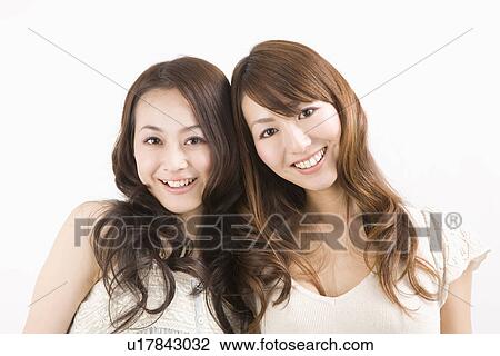 Two young women smiling View Large Photo Image Stock Image - Two young women smiling. Fotosearch