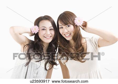 Two young women smiling View Large Photo Image Stock Photo - Two young women smiling. Fotosearch