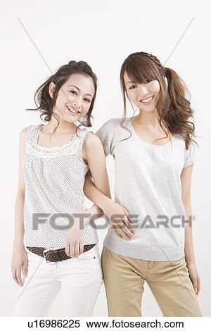 Two young women standing View Large Photo Image Stock Photography - Two young women standing. Fotosearch
