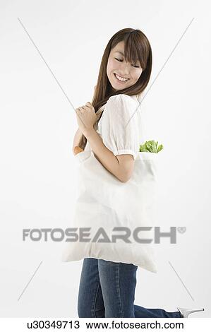 Stock Image - Young woman holding Eco bag. Fotosearch