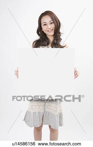 Young woman holding message board View Large Photo Image Stock Photograph - Young woman holding message board. Fotosearch