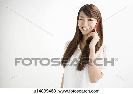 Stock Photo - Young woman holding mobile phone. Fotosearch