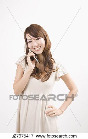 Stock Photo - Young woman holding mobile phone. Fotosearch