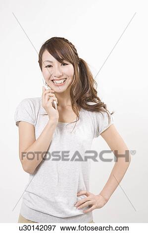 Young woman holding mobile phone View Large Photo Image Stock Photo - Young woman holding mobile phone. Fotosearch