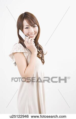 Stock Photograph - Young woman holding mobile phone. Fotosearch
