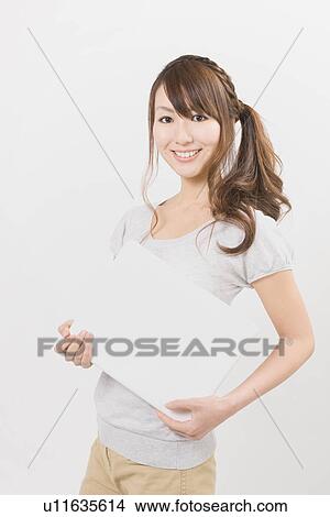 Picture - Young woman holding notebook computer. Fotosearch