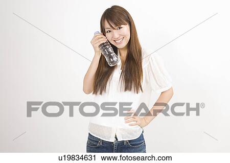 Young woman holding plastic bottle View Large Photo Image Stock Image - Young woman holding plastic bottle. Fotosearch