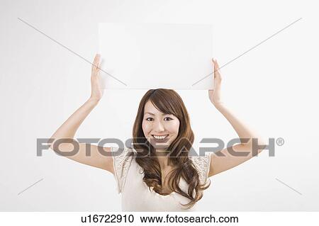 Stock Image - Young woman holding up message board. Fotosearch