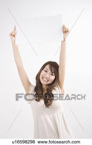 Young woman holding up message board View Large Photo Image Stock Photo - Young woman holding up message board. Fotosearch