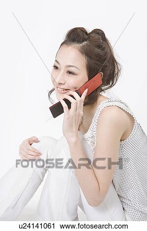 Young woman talking on mobile phone View Large Photo Image Stock Image - Young woman talking on mobile phone. Fotosearch