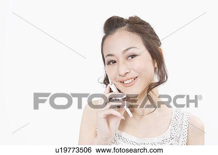 Stock Photograph - Young woman talking on mobile phone. Fotosearch