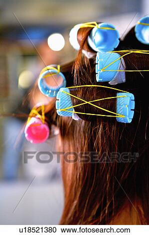 Stock Image - Close-up of curlers on young woman's hair, Hair Salon. Fotosearch