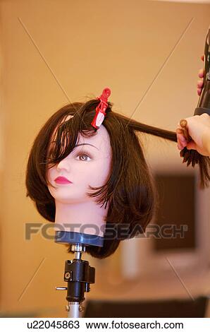 Stock Image - Hairdresser using wig for practicing, Hair Salon. Fotosearch