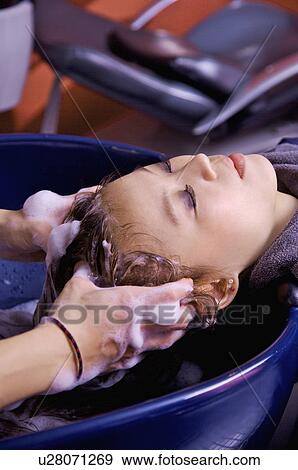 Stock Photo - Young woman having her hair washed, Hair Salon. Fotosearch