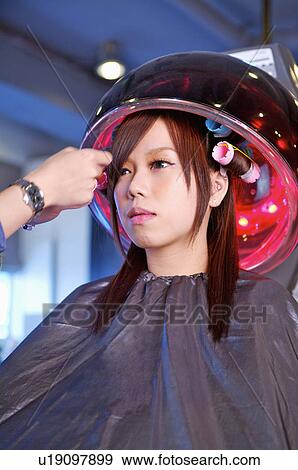 Young woman sitting under hair dryer, Hair Salon View Large Photo Image Stock Photo - Young woman sitting under hair dryer, Hair Salon. Fotosearch