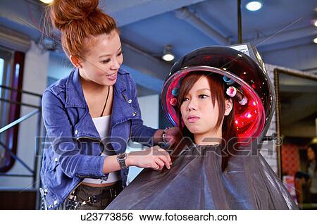 Young woman sitting under hair dryer, Hair Salon View Large Photo Image Stock Photograph - Young woman sitting under hair dryer, Hair Salon. Fotosearch