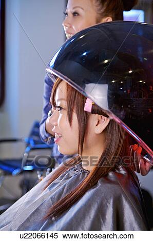 Young woman sitting under hair dryer and smiling, Hair Salon View Large Photo Image Stock Photography - Young woman sitting under hair dryer and smiling, Hair Salon. Fotosearch