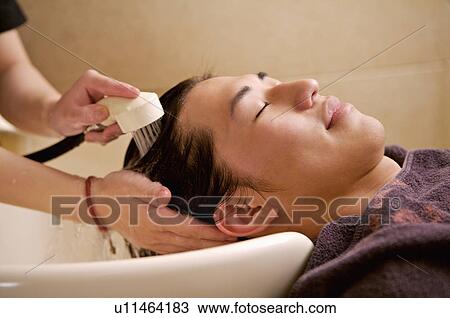 Stock Image - Young man having hair washed, Hair Salon. Fotosearch