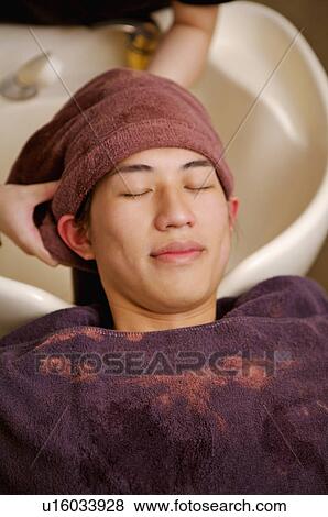 Stock Photo - Young man having his hair washed, Hair Salon. Fotosearch