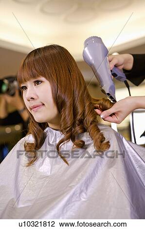 Young woman having her hair curled and dried, Hair Salon View Large Photo Image Stock Image - Young woman having her hair curled and dried, Hair Salon. Fotosearch
