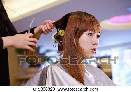 Stock Photo - Young woman having her hair curled, Hair Salon. Fotosearch
