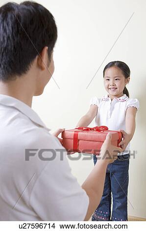 Picture - Family, a girl giving a present to her father. Fotosearch
