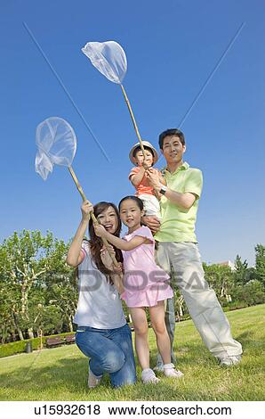 Stock Photo - Family catching bugs outdoors. Fotosearch