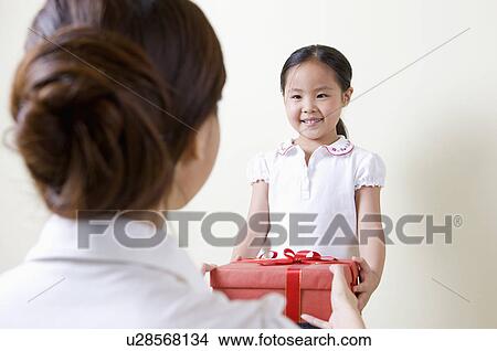 Picture - Family, daughter receiving gift from mother. Fotosearch