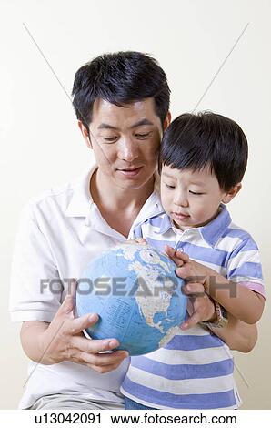 Stock Image - Family, father and son holding a globe. Fotosearch