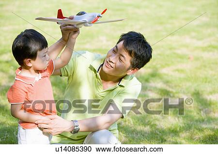 Stock Image - Family, father and son playing airplane. Fotosearch