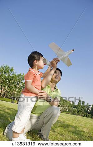 Stock Photo - Family, father and son playing toy airplane. Fotosearch