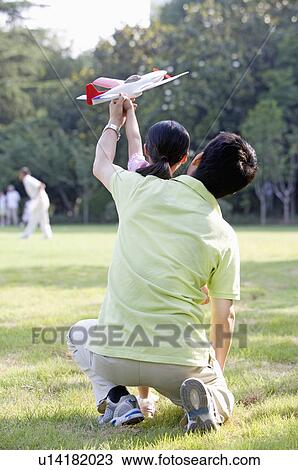 Family, father playing toy airplane with his daughter outdoors View Large Photo Image Stock Image - Family, father playing toy airplane with his daughter outdoors. Fotosearch
