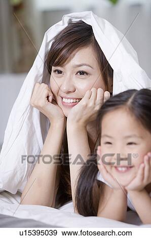 Stock Photo - Family, mother and daughter lying in bed. Fotosearch