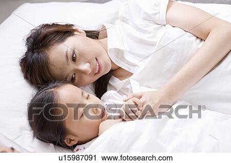 Family, mother and daughter sleeping in the bed View Large Photo Image Stock Image - Family, mother and daughter sleeping in the bed. Fotosearch