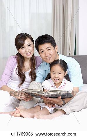 Family, parents and daughter reading together at home View Large Photo Image Stock Photography - Family, parents and daughter reading together at home. Fotosearch