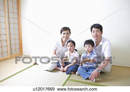 Family, Parents and two children sitting on floor, watching TV View Large Photo Image Stock Photo - Family, Parents and two children sitting on floor, watching TV. Fotosearch