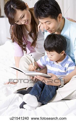Stock Image - Family, parents teaching son to write. Fotosearch