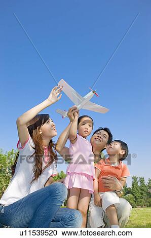 Family playing toy airplane outdoors View Large Photo Image Stock Image - Family playing toy airplane outdoors. Fotosearch