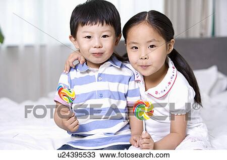 Family, Portrait of two children looking at the camera, holding a lollipop View Large Photo Image Stock Image - Family, Portrait of two children looking at the camera, holding a lollipop. Fotosearch