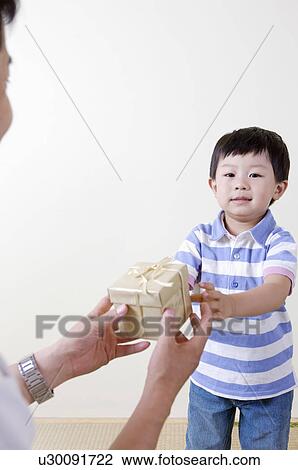 Stock Image - Family, son giving a present to his father. Fotosearch