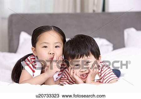 Stock Image - Family, two children lying in bed. Fotosearch