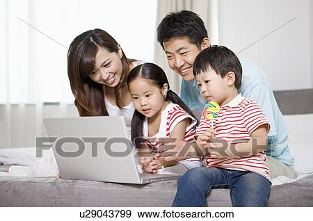 Family using laptop View Large Photo Image Stock Photo - Family using laptop. Fotosearch