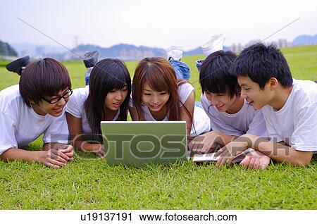Five teenagers lying on the lawn and looking at the laptop together, Teenager View Large Photo Image Stock Image - Five teenagers lying on the lawn and looking at the laptop together, Teenager. Fotosearch