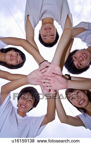 Five teenagers putting hands together in a stack and looking down, Teenager View Large Photo Image Stock Photo - Five teenagers putting hands together in a stack and looking down, Teenager. Fotosearch